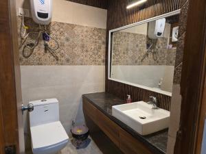 a bathroom with a sink and a toilet and a mirror at Siri Stays in Greater Noida +4 photos