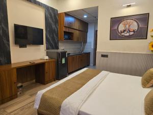 a bedroom with a bed and a flat screen tv at Siri Stays in Greater Noida