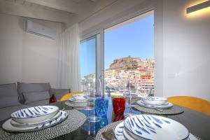 a dining room table with a view of a city at Suite HollidayHouse - vista mare in Castelsardo