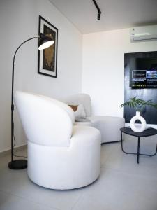 a living room with a white chair and a lamp at Divina Tower Apart Hotel in Asunción +52 photos