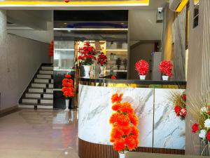a lobby with red flowers in white vases at Hotel Shanti Residency Vrindavan in Vrindāvan