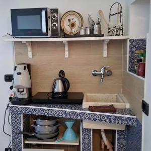 a tiny kitchen with a stove and a microwave at Lighthouse Taranto in Taranto