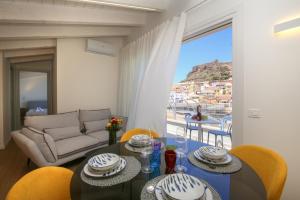 a living room with a table and chairs and a couch at Suite HollidayHouse - vista mare in Castelsardo