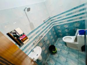 a blue and white bathroom with a toilet and a sink at Rooms Varkala Homestay in Varkala