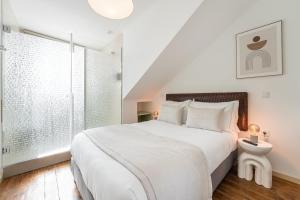 a white bedroom with a large bed and a window at GuestReady - Vanzeleres Collection in Porto +50 photos