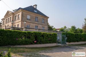 a large house with a gate in front of a hedge at gîte dans maison bourgeoise in Millau