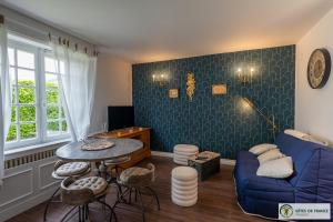 a living room with a blue couch and a table at gîte dans maison bourgeoise in Millau
