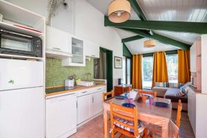 a kitchen and dining room with a table and chairs at House with small garden and shared pool in Moliets-et-Maa