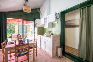 a kitchen and dining room with a table and chairs at House with small garden and shared pool in Moliets-et-Maa