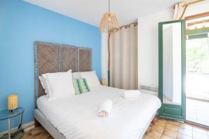 a bedroom with a white bed with a blue wall at House with small garden and shared pool in Moliets-et-Maa