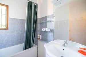 a bathroom with a tub and a sink and a shower at House with small garden and shared pool in Moliets-et-Maa +17 photos