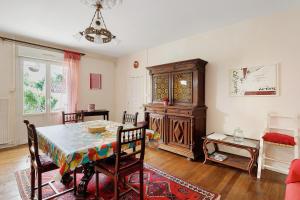 a dining room with a table and a cabinet at Gîte La Bonnetière in Joué-lès-Tours