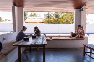 a group of people sitting around a table in a room at Hangten's Surf Skate Hostel in Arugam Bay