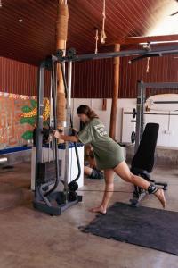 a woman is exercising in a gym at Hangten's Surf Skate Hostel in Arugam Bay