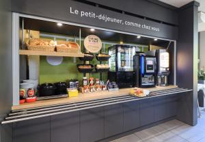a bakery with a counter with pastries and bread at B&B HOTEL BEAUNE Nord in Savigny-lès-Beaune
