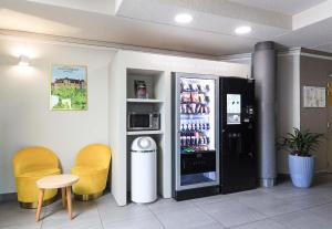 a restaurant with a refrigerator and two yellow chairs at B&B HOTEL BEAUNE Nord in Savigny-lès-Beaune +41 photos