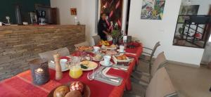 a table with a red table cloth with food on it at MAISON VATOSOA in Talata-maty