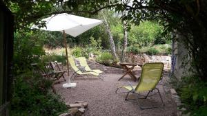 a patio with a table and chairs and an umbrella at "La Résistance" proche du Pal in Loddes