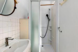 a shower in a bathroom with a sink and a mirror at Gîte La Bonnetière in Joué-lès-Tours
