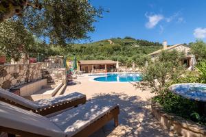 a resort with a swimming pool and a mountain at Joanna's Stone Villas in Vasilikos