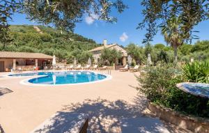 a swimming pool in a resort with a mountain in the background at Joanna's Stone Villas in Vasilikos +104 photos
