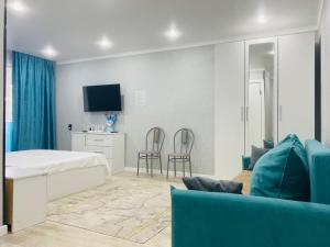 a bedroom with a bed and a blue couch at Elegant Home Apart in Karagandy