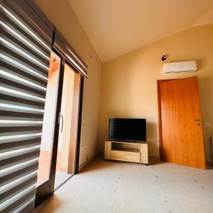 a living room with a television and a door at Aura Apartment in Senorbì