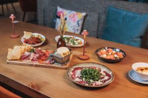 a wooden table with plates of food on it at Praia do Sal Resort & SPA in Alcochete +141 photos