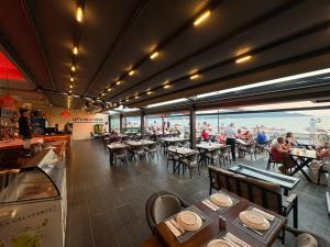 a restaurant with tables and people sitting at tables at Olimpia Hotel in Fethiye