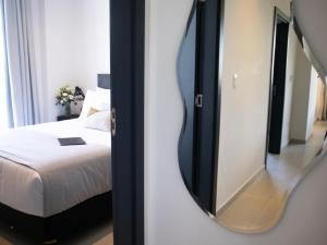 a bedroom with a mirror next to a bed at Divina Tower Apart Hotel in Asunción