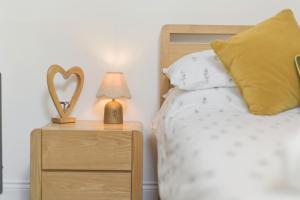 a bedroom with a bed and a nightstand with a heart lamp at 20 Applegrove in Monifieth