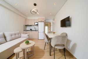 a living room with a couch and a table and chairs at Ilias Suites in Skala Potamias