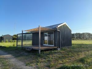 a small black tiny house in a field at Hoxhohl Travel Lodge in Colonia del Sacramento +9 photos