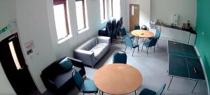 a room with a couch and tables and chairs at Linlithgow Lodge in Linlithgow