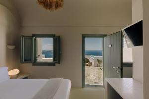 a bedroom with a bed and a view of the ocean at Agave Santorini Design Boutique Hotel in Imerovigli