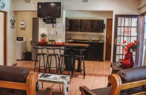 a living room with a kitchen with a bar in it at Charming Self Catering Apartment in Phalaborwa