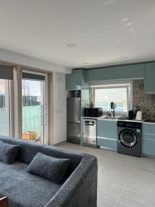 a living room with a couch and a kitchen at casa da Inês in Vieira de Leiria
