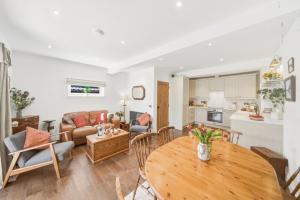 a living room with a table and a kitchen at 20 Applegrove in Monifieth