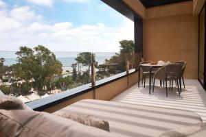 a balcony with a table and chairs and a view of the ocean at Insotel Fenicia Prestige Suites & Spa in Santa Eularia des Riu
