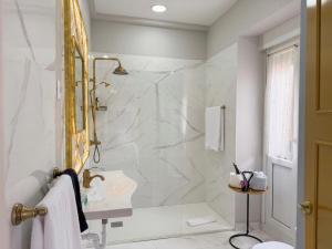 a white bathroom with a shower and a sink at Hostal Boutique Puerta del Sol in Torrelavega