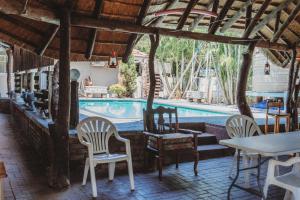 a resort with a swimming pool and chairs and a table at Charming Self Catering Apartment in Phalaborwa