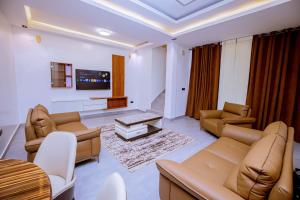 a living room with couches and a tv at The Moon Apartment in Kigali