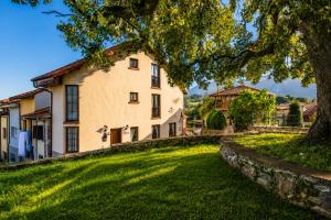 an exterior view of a house with a tree at Llanes Casa cerca Playa y Centro – Encina Pancar in Pancar