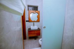 a bathroom with a sink and a mirror and a toilet at The Moon Apartment in Kigali +22 photos