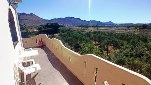 a balcony with chairs and a view of the mountains at Genos suites in Stavros