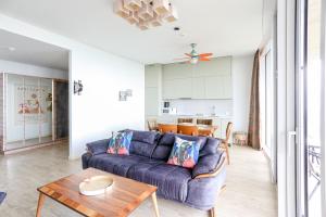 a living room with a blue couch and a table at Green Cape Botanico in Batumi