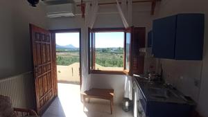 a kitchen with a window and a sink and a table at Genos suites in Stavros