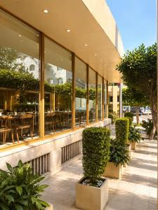 a restaurant with tables and plants in front of a building at Maadi Hotel in Cairo