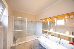 a bathroom with a tub and a sink at Maison Bellevue in Brunstatt +20 photos