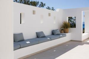 a bench with blue pillows on a white wall at Acron Vigla in Mikri Vigla +27 photos